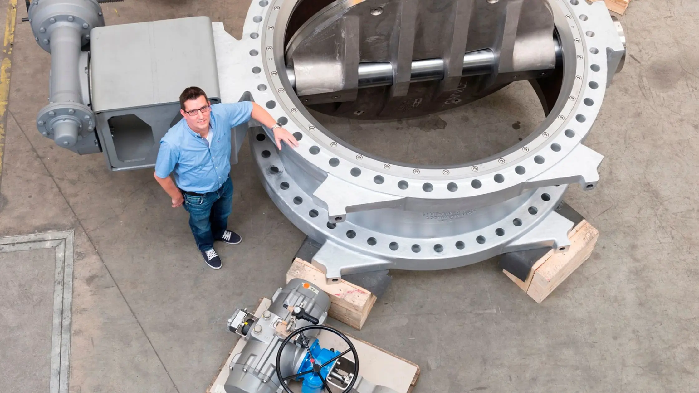 Engenheiro industrial ao lado de uma válvula de controle tipo borboleta