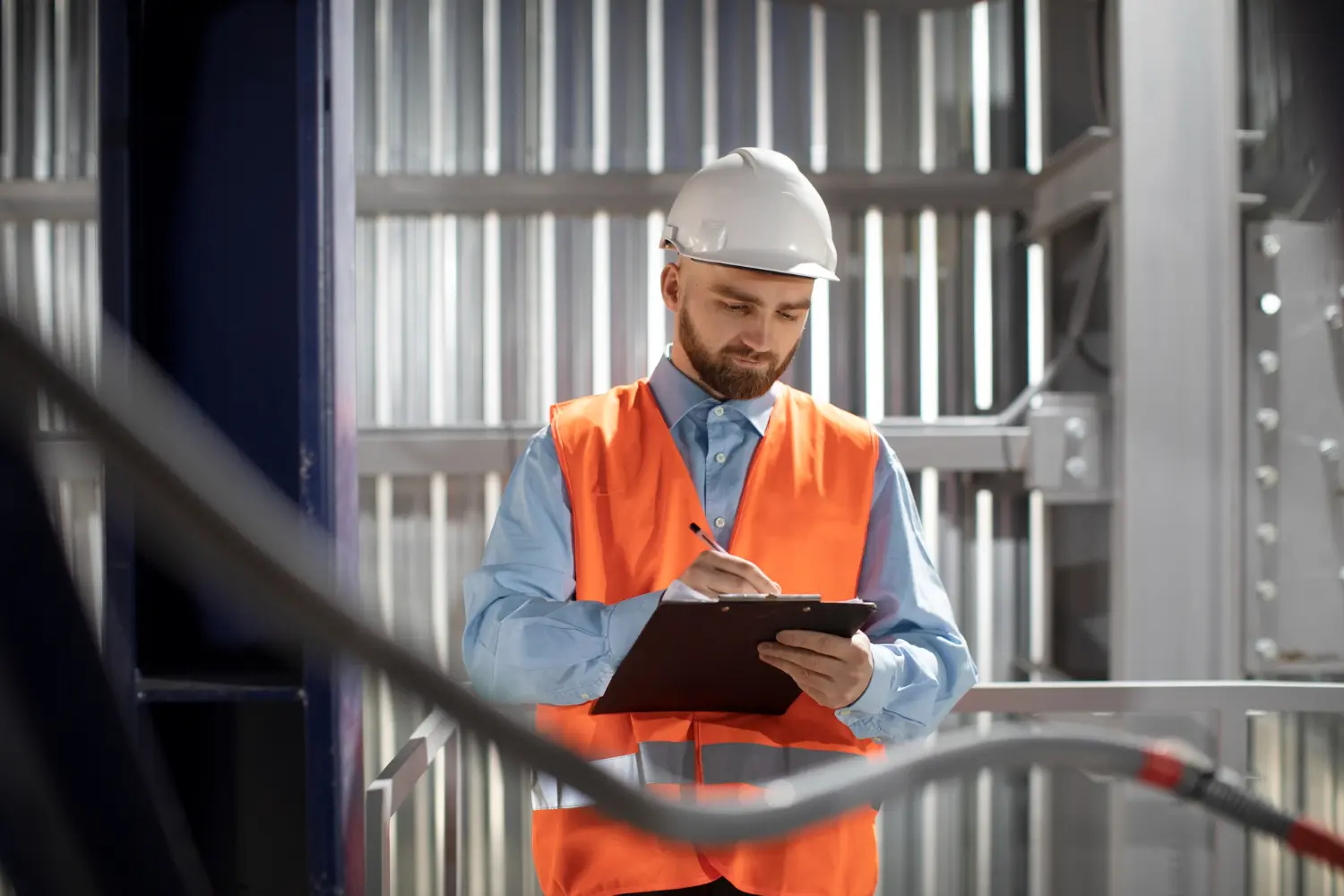 Engenheiro faz anotações em uma prancheta, simbolizando a adoção de checklist de manutenção preventiva em processos industriais.