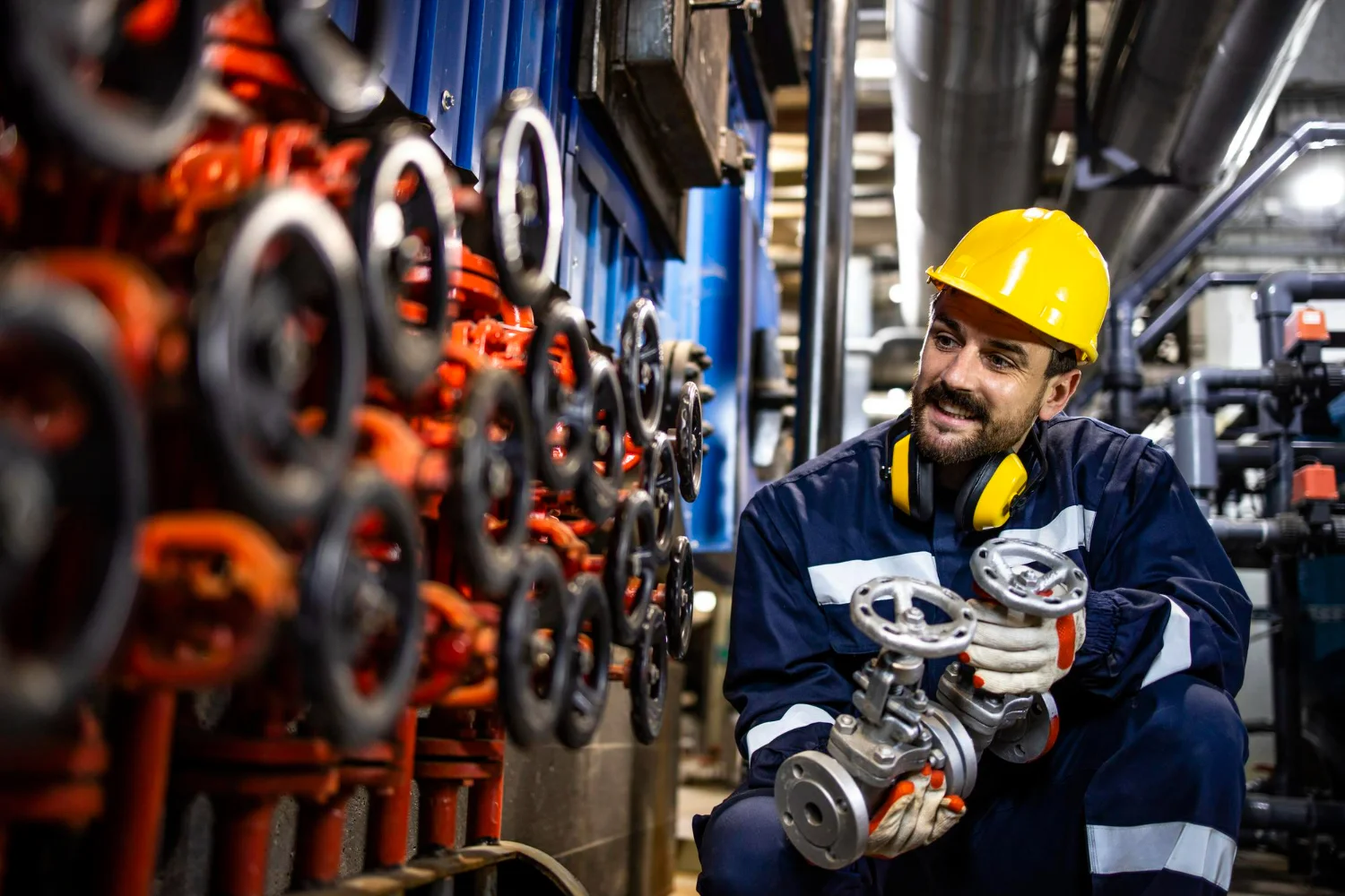 Imagens de um engenheiro fazendo a troca e manutenção de válvulas industriais.