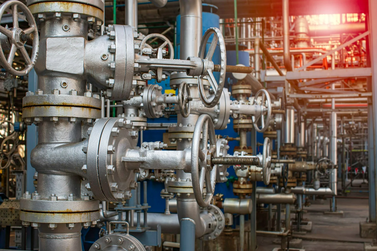Planta industrial repleta de tubulações, destacando a importância de calcular o custo total de propriedade em válvulas de controle.